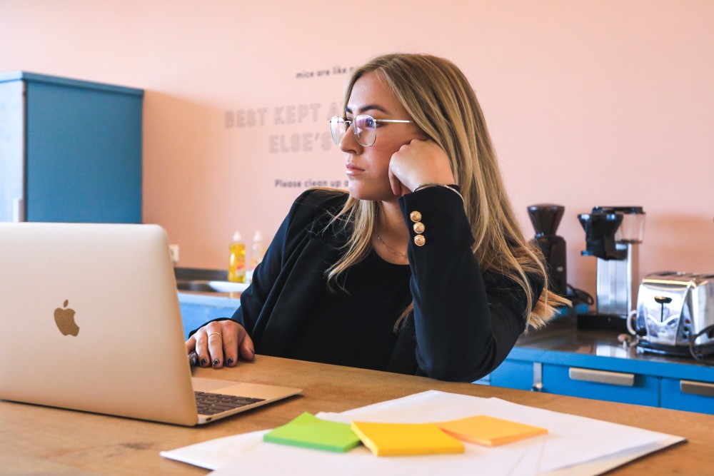 Girl in office working on an Apple laptop