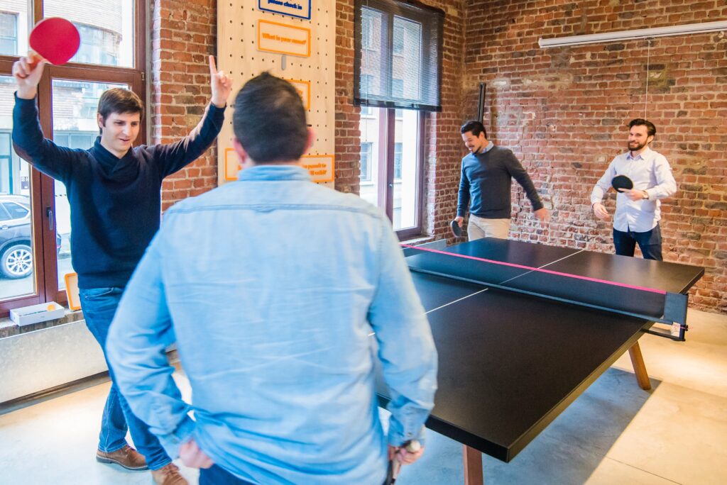 happy employees playing ping pong 