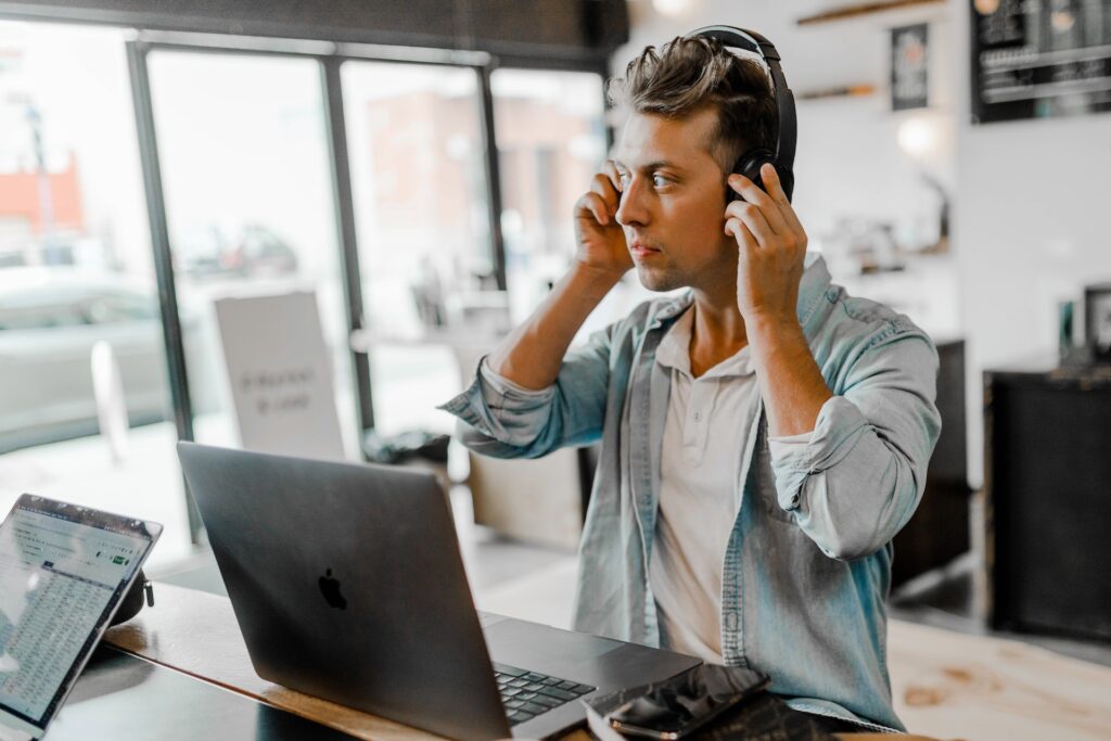 young man putting on headphones in a professional setting. 